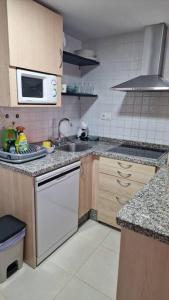 a kitchen with a sink and a microwave at Alojamiento con terraza 1B02 en la Playa de Vera. in Vera +3 photos