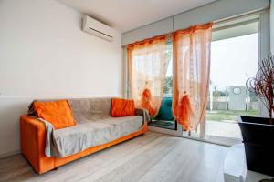 um sofá laranja num quarto com uma grande janela em Beach & Relax em Lido di Jesolo