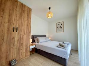 - une chambre avec un lit et une grande porte en bois dans l'établissement Vestovis Holiday House, à Mostar