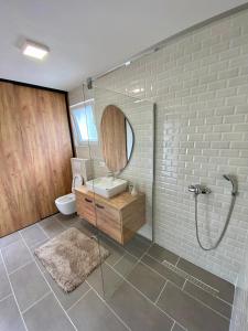a bathroom with a shower and a sink and a mirror at Vestovis Holiday House in Mostar