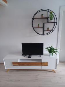 ein weißes Wohnzimmer mit einem TV und einem Spiegel in der Unterkunft Apartment Roza in Cres