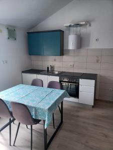 eine Küche mit einem Tisch, Stühlen und einer Theke in der Unterkunft Apartment Roza in Cres