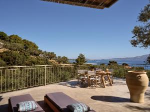 a patio with a table and chairs and a view of the water at Fairytale villas & suites marathias zakynthos in Marathias
