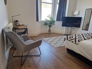 um quarto com uma cama, uma cadeira e uma secretária em West Beck House - Newcastle 3 em North Shields