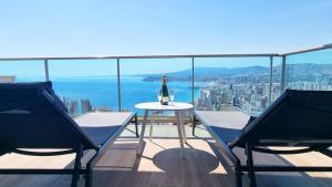 a bottle of wine sitting on a table on a balcony at Skyscraper apartment with panoramic views - floor 38 in Benidorm