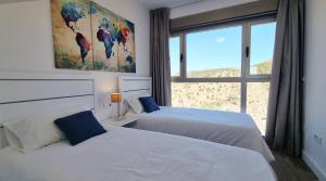 two beds in a room with a window at Skyscraper apartment with panoramic views - floor 38 in Benidorm