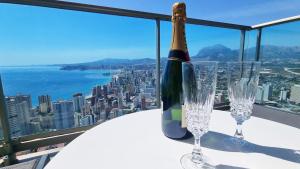 a bottle of champagne sitting on a table with two glasses at Skyscraper apartment with panoramic views - floor 38 in Benidorm