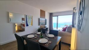 a living room with a table with chairs and a dining room at Skyscraper apartment with panoramic views - floor 38 in Benidorm