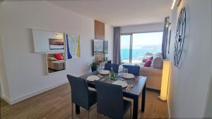 a dining room with a table and a living room at Skyscraper apartment with panoramic views - floor 38 in Benidorm