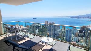 a balcony with a table and a view of the ocean at Skyscraper apartment with panoramic views - floor 38 in Benidorm