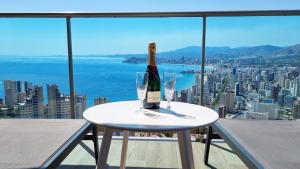 a bottle of wine and two glasses on a table at Skyscraper apartment with panoramic views - floor 38 in Benidorm