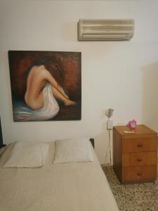 un dormitorio con una pintura de una mujer en la pared en Cuarto privado separado de la casa principal y con entrada independiente en Corrientes