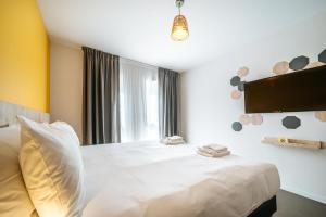 a bedroom with a white bed and a window at Beelodge Hotel Blois Centre in Blois