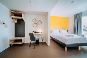 Beelodge Hotel Blois Centre في بلوا: غرفة نوم بسرير ومكتب وكرسي