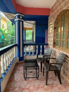 a room with chairs and a balcony with blue walls at Casa De Calangute Beach in Calangute