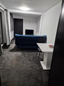 Codsall的住宿－CKB Flat- comfort, cosy, and secure!，客厅配有蓝色的沙发和桌子