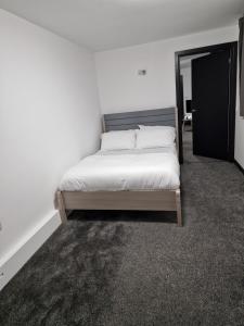 een slaapkamer met een bed in een witte kamer bij CKB Flat- comfort, cosy, and secure! in Codsall