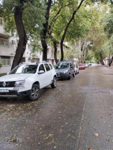 eine Reihe von Autos, die an der Straßenseite geparkt sind in der Unterkunft Mendoza Estudio Urbano in Mendoza
