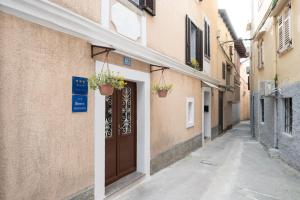a narrow alley with a door and potted plants at Apartman Kesten in Lovran