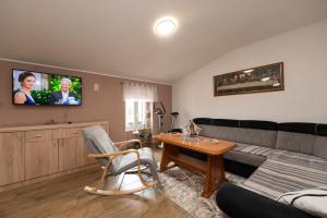 a living room with a couch and a tv on the wall at Apartman Kesten in Lovran