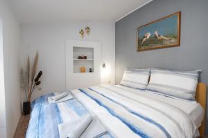 a bedroom with a large bed with blue and white sheets at Apartman Kesten in Lovran