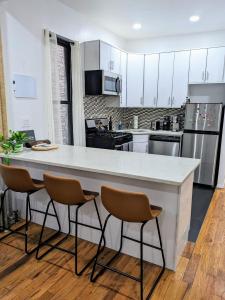a kitchen with a large white counter and chairs at Lavish Downtown Manhattan Oasis in Union Square in New York