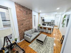 sala de estar con sofá y pared de ladrillo en Lavish Downtown Manhattan Oasis in Union Square, en Nueva York