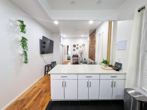 a kitchen with white cabinets and a tv on the wall at Lavish Downtown Manhattan Oasis in Union Square in New York