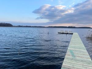 a dock on a large body of water at Kaimukas - namelis prie ežero keturiems in Dvarčėnai