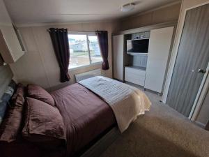 a small bedroom with a bed and a window at Thrillseeker - next to Fantasy Island, Ingoldmells in Skegness