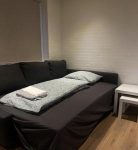 Una cama negra con una manta encima. en The Heart of Billund apartment en Billund