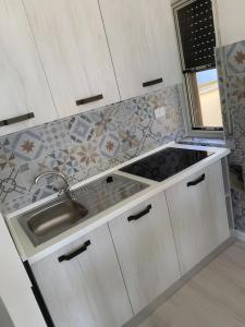 a kitchen with a sink and a counter top at Ippocampo alba e tramonto in Ippocampo