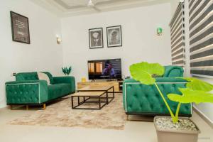 a living room with two green couches and a table at Le Calypso in Cotonou
