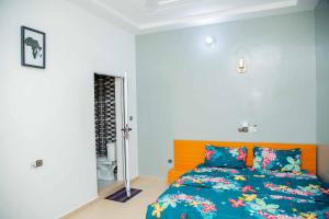 a bedroom with a bed with a blue comforter at Le Calypso in Cotonou