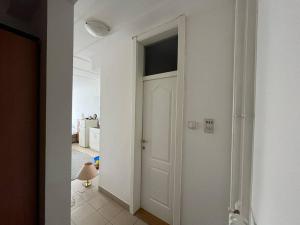 um corredor com uma porta branca num quarto em Small flat in the city heart em Novi Sad