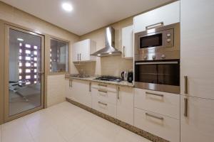 Stylish Bliss - Dream Apartment في مراكش: مطبخ مع موقد وميكروويف