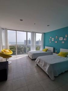 1 dormitorio con 2 camas y ventana grande en Apartamento de playa con vista al mar en coronado en Playa Coronado