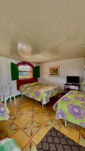 a room with two beds and a table at La Mía Hospedaje in Armenia