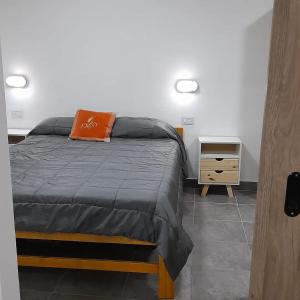 Dormitorio con cama con almohada naranja en Cabañas tu despertar en Oro Verde