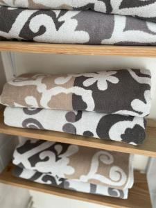 a stack of towels on a wooden shelf at Beach Bungalow - Noordwijk aan Zee in Noordwijkerhout