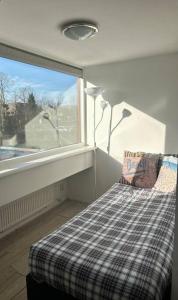a bedroom with a window and a bed with a pillow at Beach Bungalow - Noordwijk aan Zee in Noordwijkerhout
