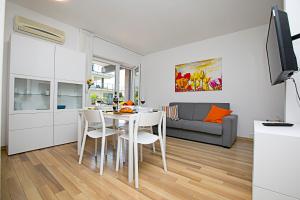 cocina y sala de estar con mesa y sillas en Riva Lago e Spiaggia Apartment 2, en Riva del Garda