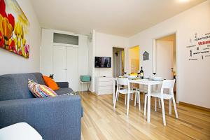 sala de estar con sofá azul y mesa en Riva Lago e Spiaggia Apartment 2, en Riva del Garda