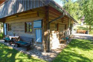 una cabaña de madera con una mesa y sillas frente a ella en Chalet Kupljenik Near Bled Lake, en Bohinjska Bela