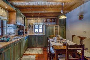 kuchnia z zielonymi szafkami i stołem z krzesłami w obiekcie Chalet Kupljenik Near Bled Lake w mieście Bohinjska Bela
