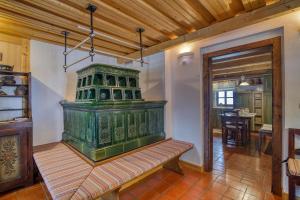 - une grande cheminée verte dans une pièce avec une table dans l'établissement Chalet Kupljenik Near Bled Lake, à Bohinjska Bela