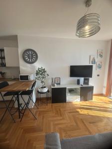 a living room with a table and a clock on the wall at Mi Casa Es Tu Casa in Rome