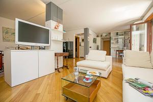 ein Wohnzimmer mit einem weißen Sofa und einem Flachbild-TV in der Unterkunft Elegance Suite Isabella in Riva del Garda
