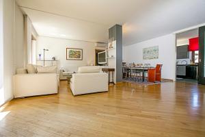 ein Wohnzimmer mit weißen Möbeln und eine Küche in der Unterkunft Elegance Suite Isabella in Riva del Garda