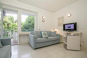 ein Wohnzimmer mit einem Sofa und einem TV in der Unterkunft Riva Lago e Spiaggia Apartment 3 in Riva del Garda